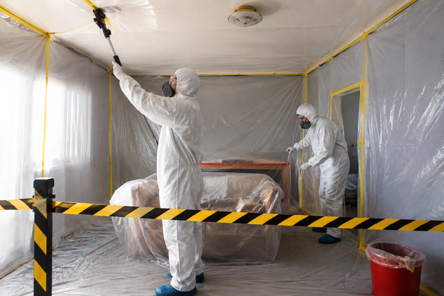Licensed contractors carrying out asbestos ceiling removal inside a Perth home using protective equipment.