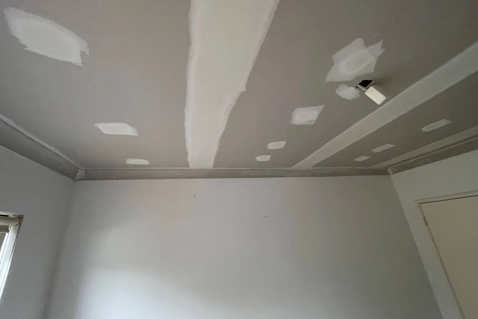 A patched section of gyprock ceiling set and sanded flat ready for paint