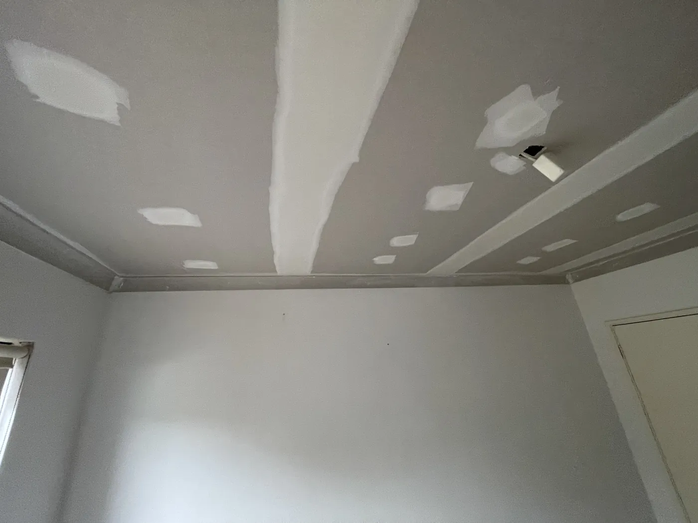 Patched screw points and taped joins across a Mandurah ceiling