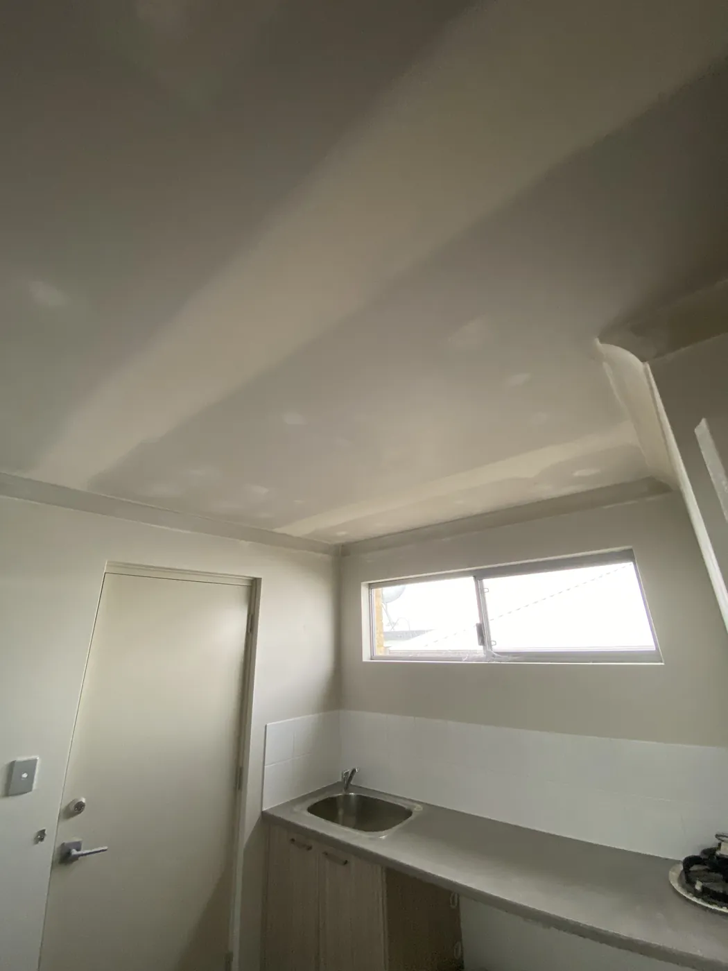 Smooth refitted laundry ceiling with a light point in a Dianella home