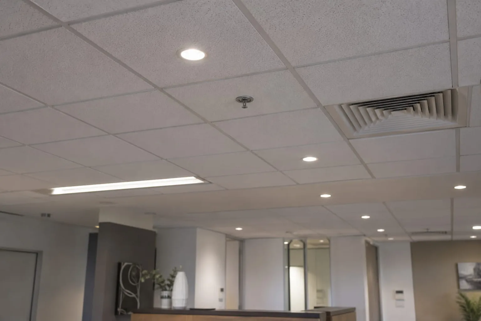 A suspended grid ceiling running the length of an office floor