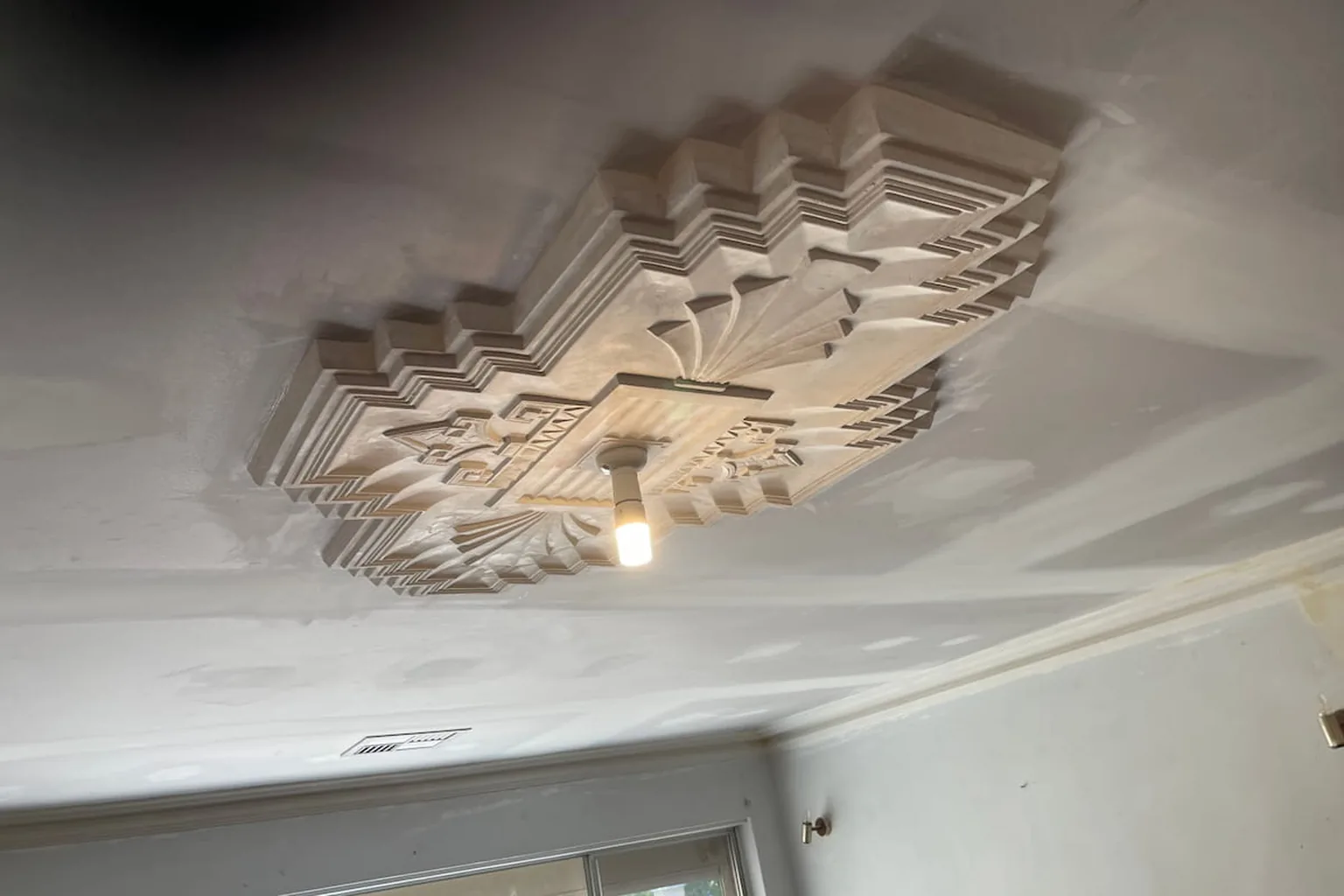 A new length of plaster cornice being set into the join between wall and ceiling